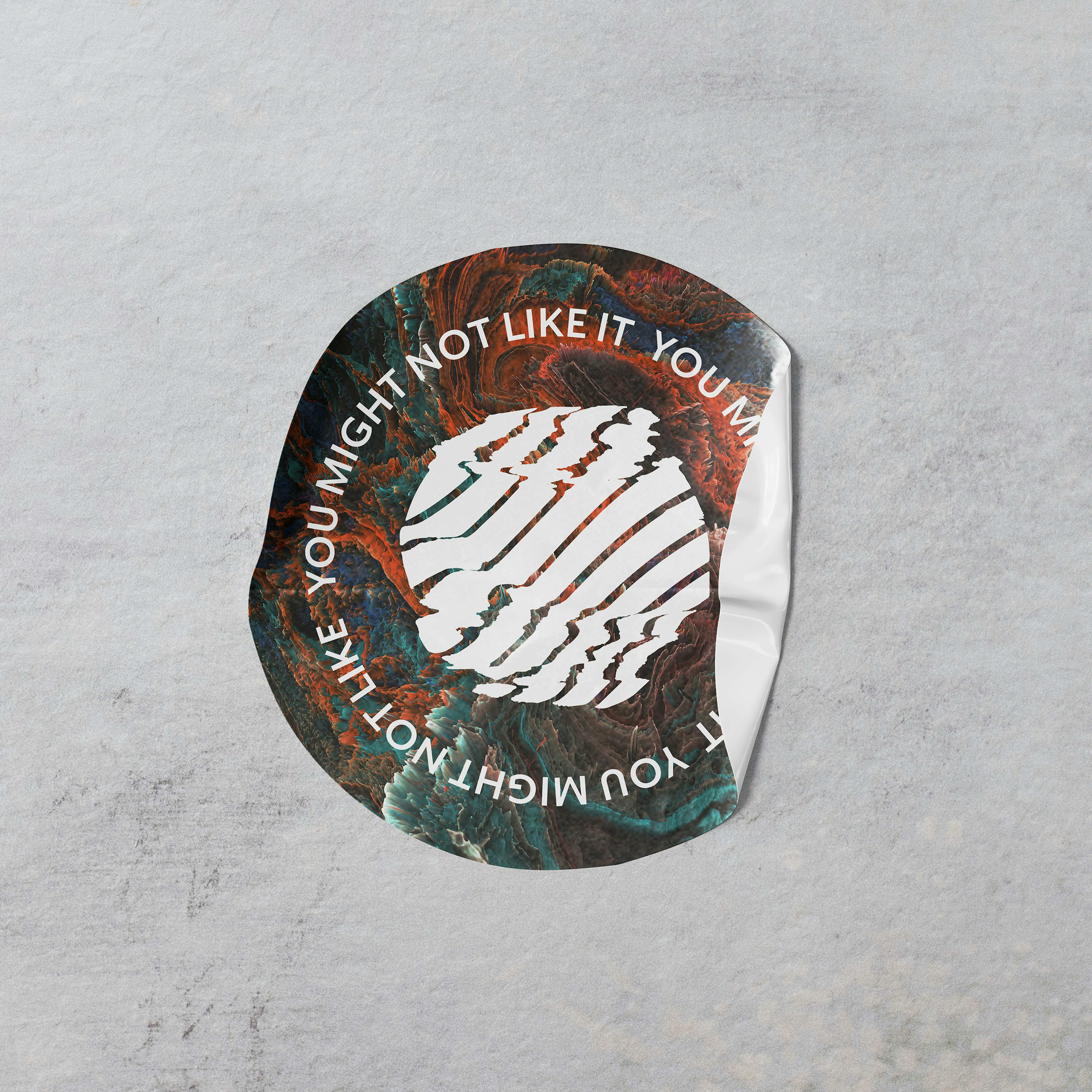 Close up of a crumpled, round vinyl sticker for the 2022 Sonorities Festival. Text reads "YOU MIGHT NOT LIKE IT".