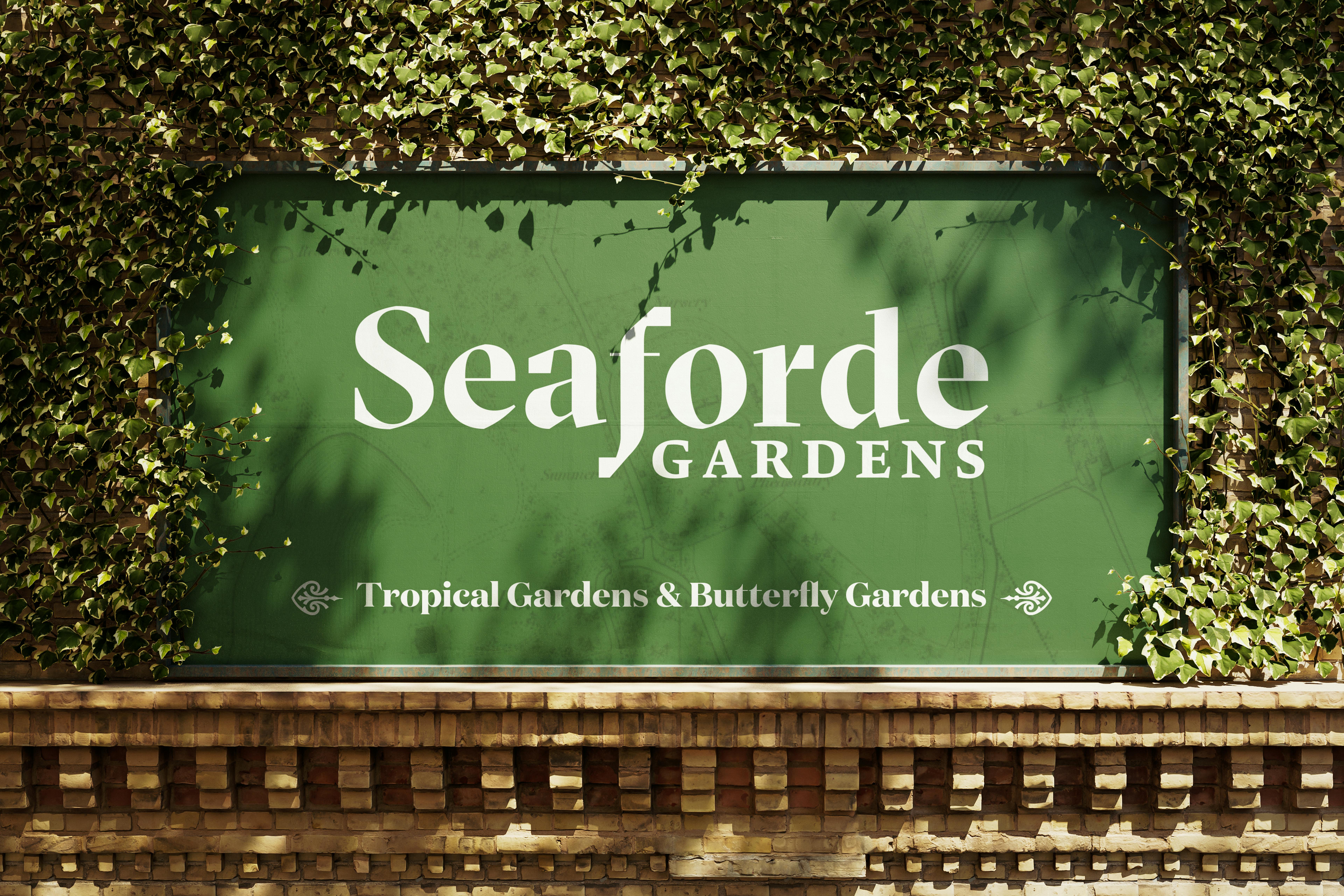 Large green Seaforde Gardens logo printed white on a green sign, surrounded by climbing ivy.